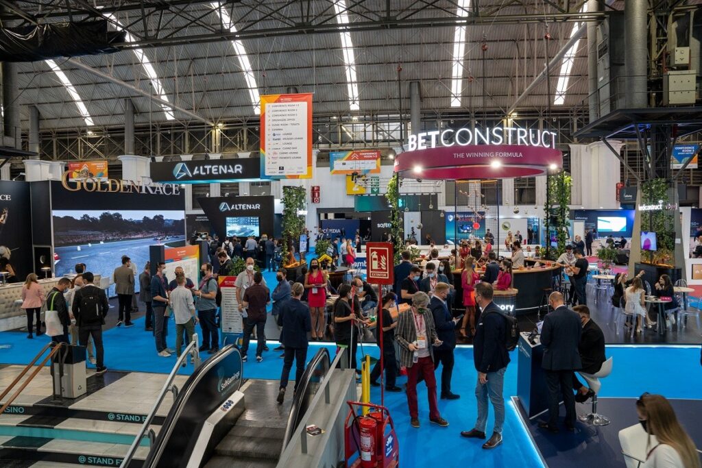 Attendees networking among branded booths on the show floor at SBC Summit Barcelona 2021.