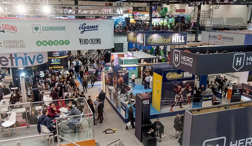 An elevated view of crowds and branded booths on the show floor at the London Affiliate Conference 2019.