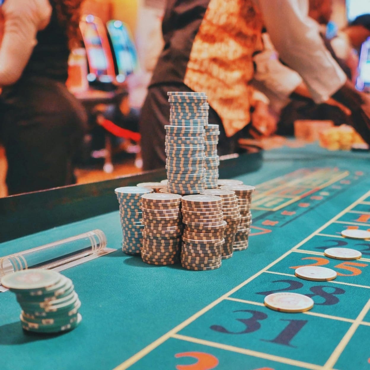 Pilas de fichas de casino sobre una mesa de ruleta verde – redacción de contenido de casinos profesional.